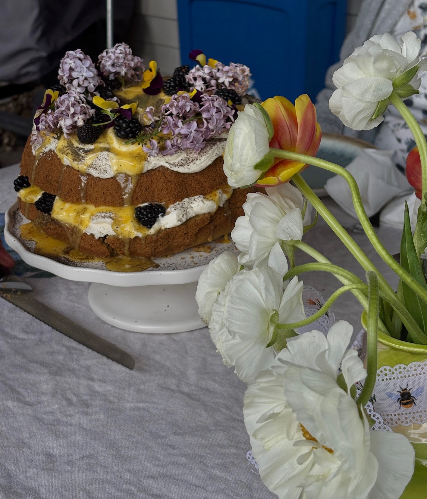 Naked cake with flowers on cake stand with garden florals
